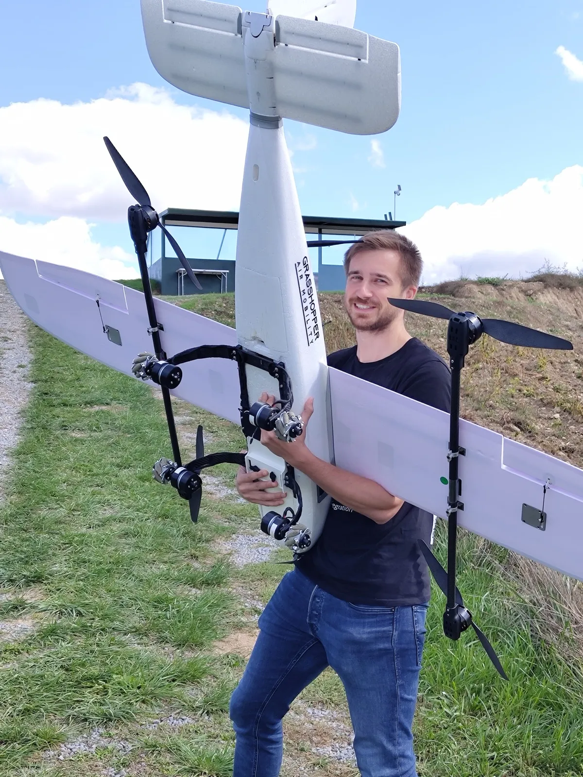 Jakob llevando el dron de prueba de concepto de Grasshopper por un campo el día del primer vuelo, septiembre de 2025.